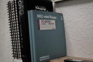 Ein paar dünne Computerbücher in auf einem Regalbrett. Ein paar davon haben einen Ringeinband